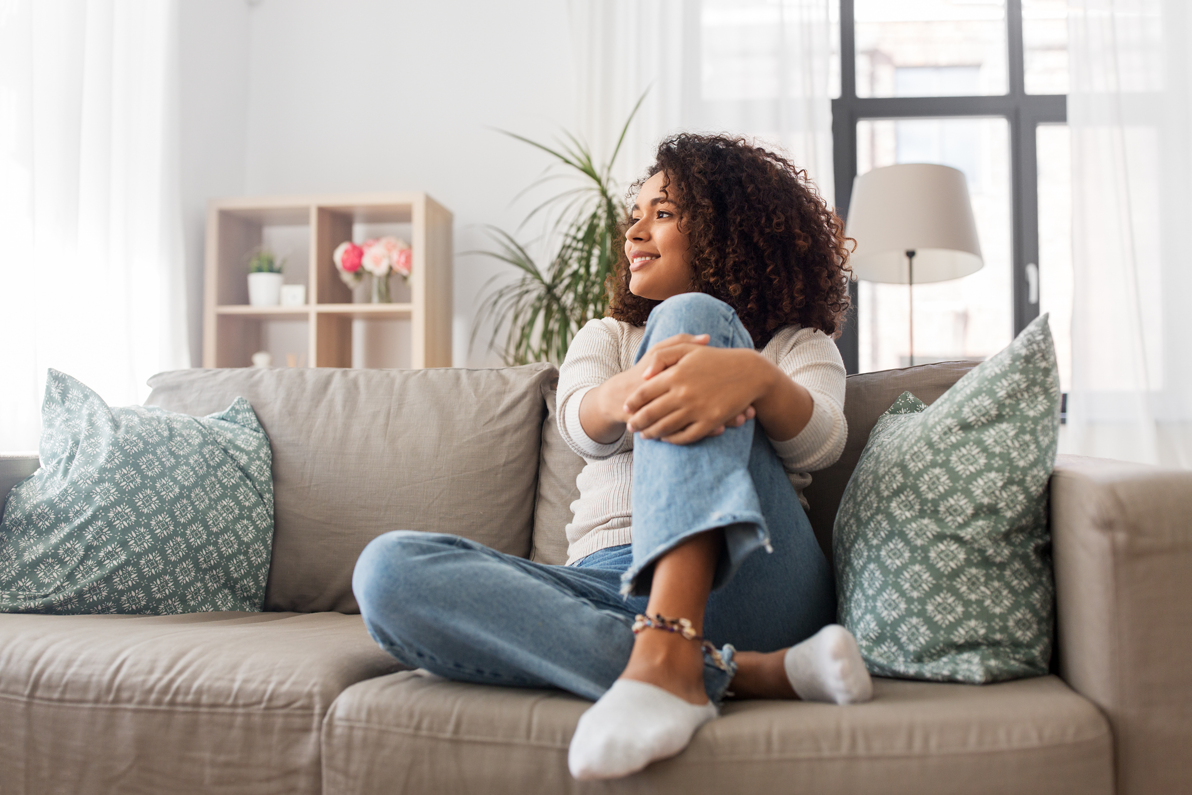 Woman relaxing on couch smiling.